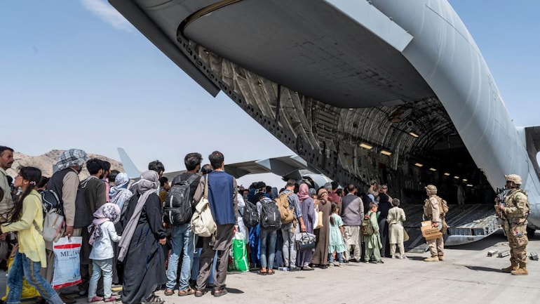 Afghans board a US Air Force evacuation plane at Kabul airport on Monday