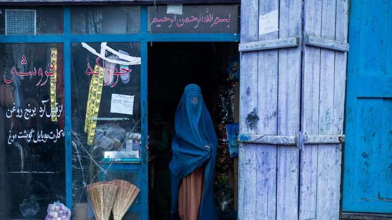 File photo of an Afghan woman wearing a burka exiting a small shop in Kabul