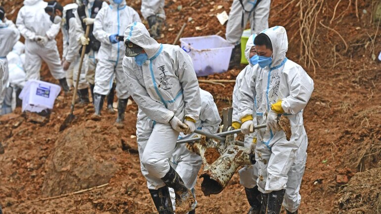 Rescuers carry a piece of plane wreckage at the site of Monday's plane crash in southern China's Guangxi Zhuang Autonomous Region. (Photo: AP/PTI) Rescuers carry a piece of plane wreckage at the site of Monday's plane crash in southern China's Guangxi Zhuang Autonomous Region. (Photo: AP/PTI)