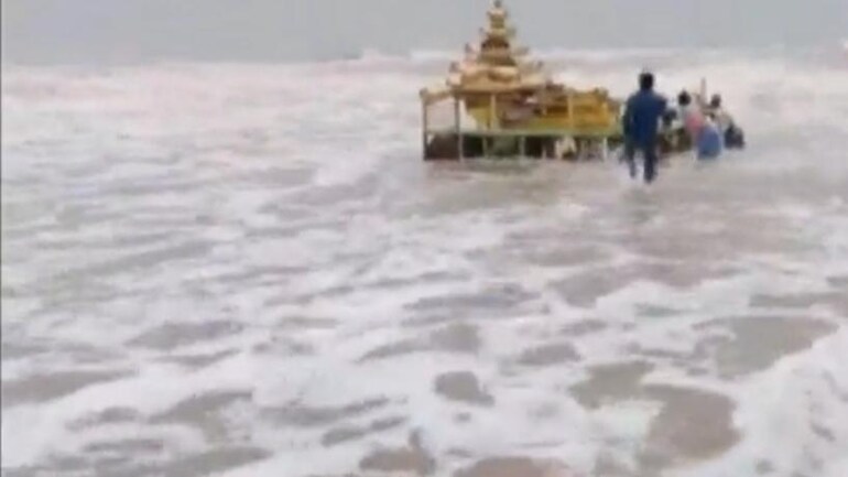 A screen grab of a video showcasing people dragging the mysterious gold-coloured chariot out of water in Srikakulam. Gold-coloured chariot, people in blue and pink shirts