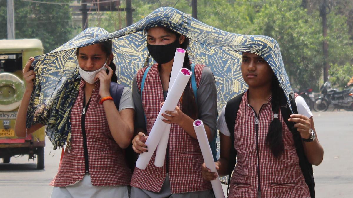 Students shield themselves from the heat with a scarf on a hot summer afternoon.