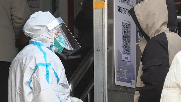 A person talking with a health worker as people queue outside a fever clinic amid the Covid-19 pandemic in Beijing (AFP photo)
