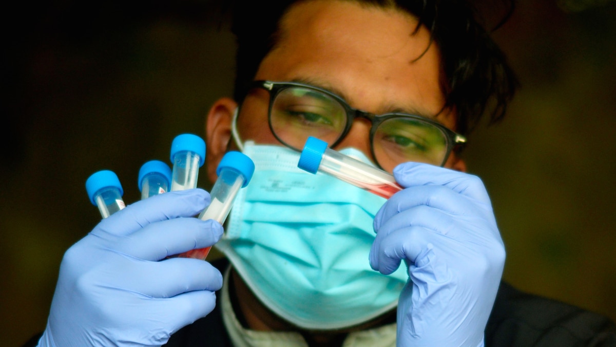 A health worker wearing face mask shows swab samples collected for the COVID-19 test, in Gurugram, Friday, Dec. 30, 2022. (Photo courtesy: PTI)