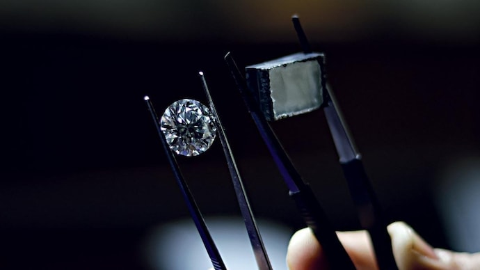 A craftsman holds a finished lab-grown diamond and a rough at a processing unit in Surat. (Photo: Nandan Dave)