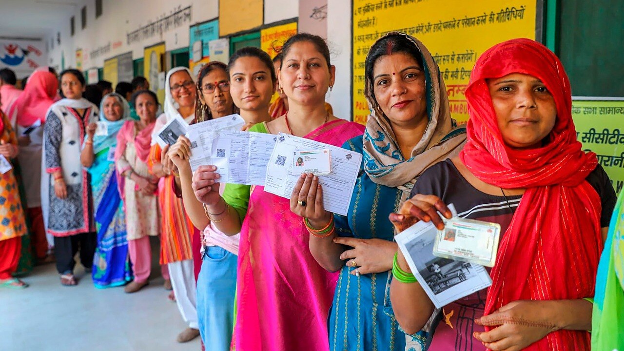 Image shows women voters waiting to cast their votes for the second phase of Lok Sabha elections in Bulandshahr. (PTI photo)