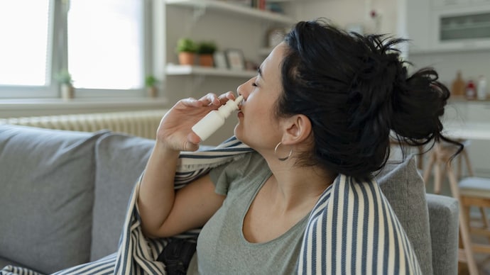 Treatment of allergies or common cold. The woman is using nasal spray drops of medicine in her nose. Rhinitis, allergy. Treatment of allergies or common cold. The woman is using nasal spray drops of medicine in her nose. Rhinitis, allergy.