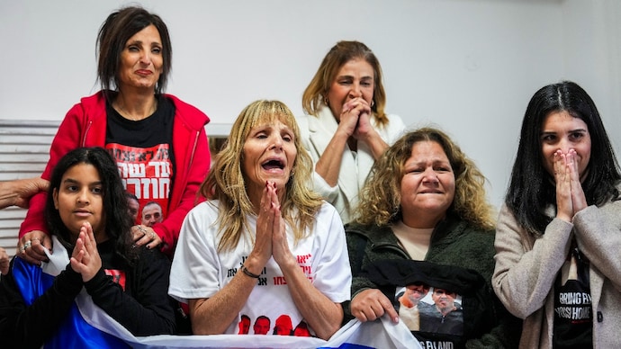 Family of Israeli hostage Eli Sharabi, whose wife and two daughters were killed on Oct. 7 attack, react as they wait the live broadcast of him being released. (AP Photo) Hamas