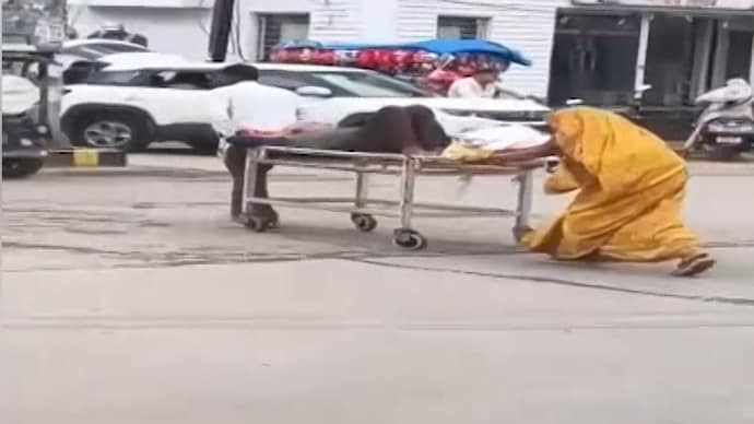 patient being wheeled out of a government hospital on a stretcher   patient being wheeled out of a government hospital on a stretcher