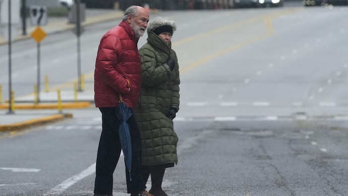 Pedestrians cross a street during a cold day in Chicago, Sunday, Nov. 9, 2025. (AP Photo/Nam Y. Huh)