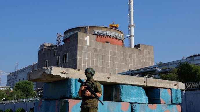 A Russian service member stands guard at a checkpoint near the Zaporizhzhia Nuclear Power Plant US Russia nuclear tests