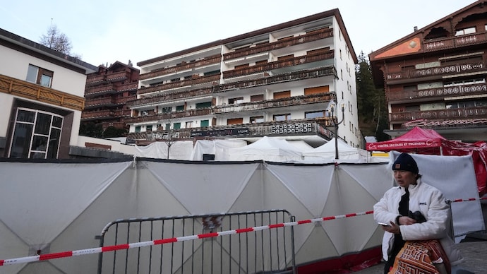 AP) A man passes the sealed off Le Constellation bar, where a devastating fire left dead and injured during the New Year's celebrations