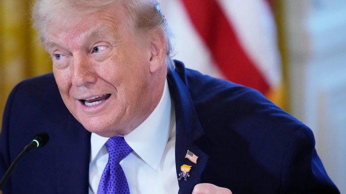 President Donald Trump wears a gift, which he calls a happy Trump pin, during a meeting with oil executives. (AP Photo) Donald Trump