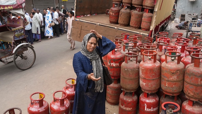 A woman outside a gas dealership in Kolkata, while people queue up for LPG refills on Thursday. (PTI Photo) A woman outside a Kolkata dealership, while people queue to refill their LPG cylinders on Thursday. (PTI Photo)