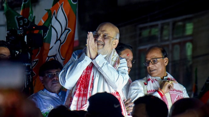 Union Home Minister Amit Shah greets supporters during a roadshow in Guwahati on Saturday, March 28, 2026. (PTI Photo) Amit Shah roadshow