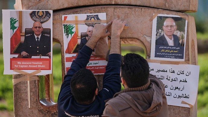 Family members of retired Lebanese officer Ahmed Shukr, hang posters of him during a gathering outside the headquarters of the UN Economic and Social Commission for Western Asia in Beirut. (AP photo)