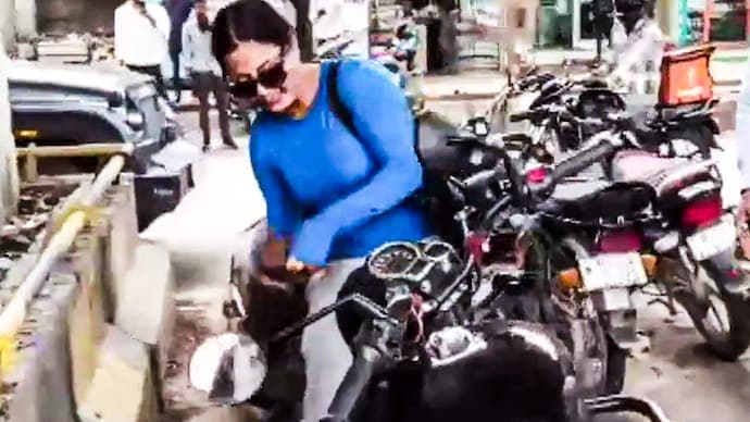 A woman vandalises a Bullet with a stone after a minor accident involving the bike, a scooter and a cab in Jaipur.