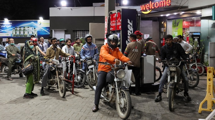 Reuters) People wait for their turn to get fuel at a petrol station in Karachi, Pakistan