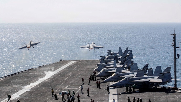 Two F/A-18 Super Hornets launch from the flight deck of the US Navy Nimitz-class aircraft carrier USS Abraham Lincoln US Iran war