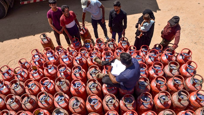 A staffer of an LPG dealership with customers at a gas agency in Karnataka's Chikkamagaluru. (PTI Photo) A delivery agent deals with customers at a gas agency, in Karnataka's Chikkamagaluru. (PTI Photo)