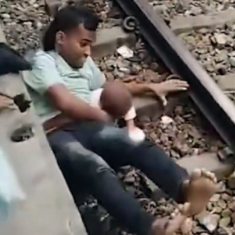 Bangladesh father shields child under moving train in dramatic rescue video
