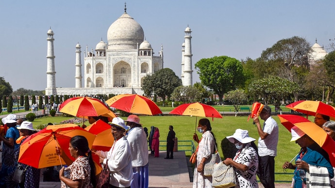 Tourists shield themselves from the sun on a scorching day in Agra, Uttar Pradesh. (Photo: PTI) Beware: Climate change has set its sight on your vacation experience