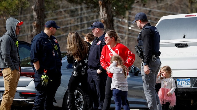 Parents who pulled out their kids from the Temple Israel Synagogue stand near police after the Michigan State Police reported an active shooting incident there, in West Bloomfield, Michigan, US, March 12, 2026. (Photo- Reuters)