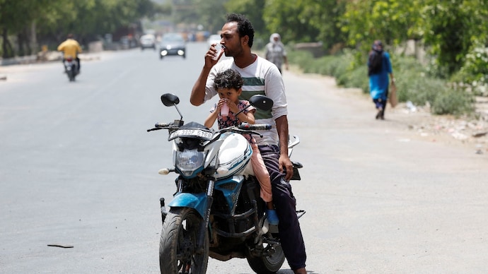 A man and a child drink cooling drinks on a hot summer day in New Delhi. (Photo: Reuters) Feeling hot? It's going to get hotter: Will Delhi see first heatwave?
