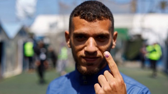 A Palestinian man, Mohammed al-Hasanat, shows his inked finger after voting during the municipal election at a polling station in Deir al-Balah, central Gaza Strip ( Photo- Reuters)