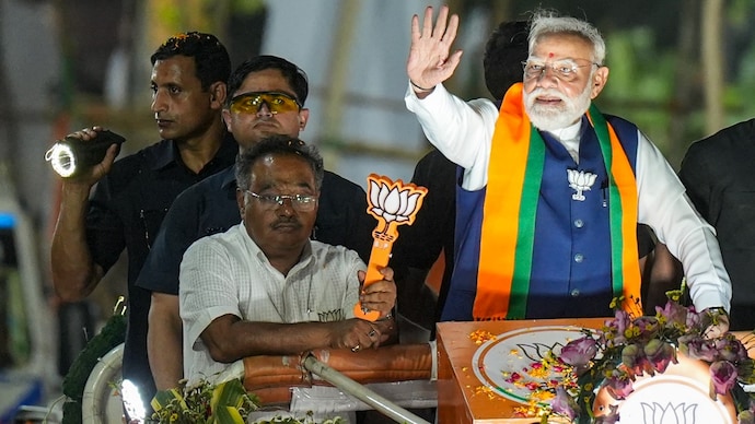 Prime Minister Narendra Modi with West Bengal BJP president Samik Bhattacharya during a roadshow in Kolkata on Sunday. (Photo: PTI)