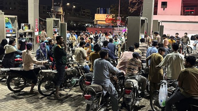 People on their vehicles wait for their turn to get fuel at a petrol station in Karachi. (Reuters Photo) Pak fuel rate spike