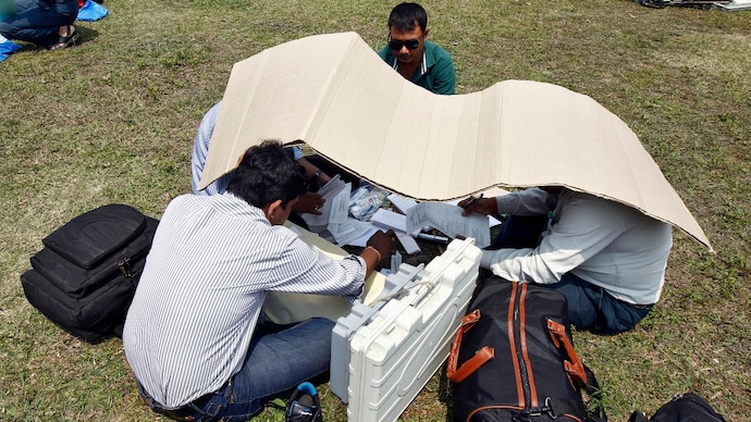 Polling officers take shelter from the heat as they check electronic voting machines in Assam. (Photo: Reuters) Polling officers take shelter from the heat as they check electronic voting machines in Assam. (Photo: Reuters)