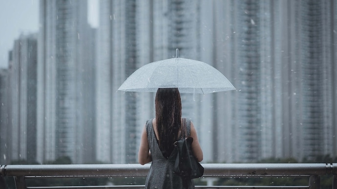 Participants who reported higher levels of loneliness had a 19% increased risk of developing degenerative valvular heart disease. (Photo: Getty Images) Rear view of young businesswomen with umbrella overlooking the city on a rainy and gloomy day, with blurry highrise residential blocks in the background.