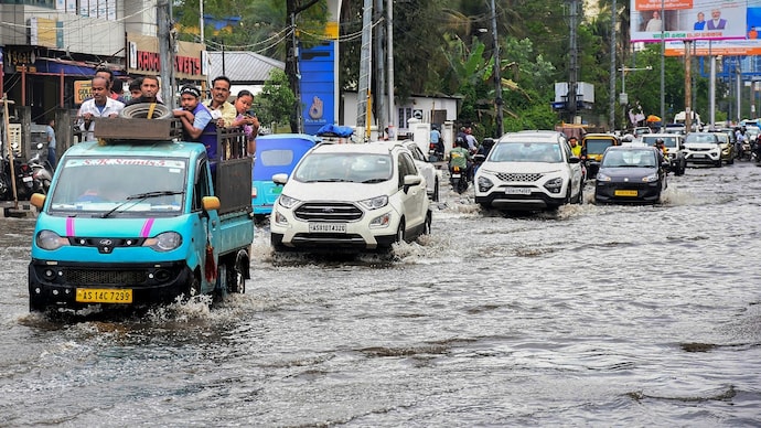 Commuters wade through a waterlogged road following rainfall. (Photo: PTI) Sunny in March, rainy in April: Why is India's weather spiralling?