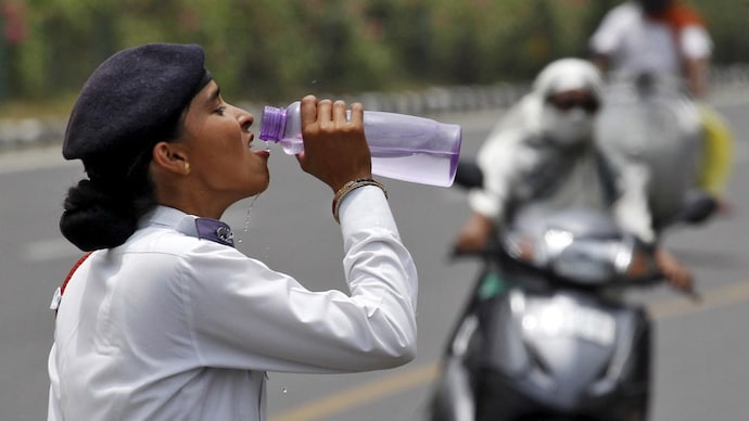 A traffic police officer drinks water on a hot day in New Delhi. (Photo: Reuters) Yellow alert in Delhi, heatwaves to begin hitting these states from today