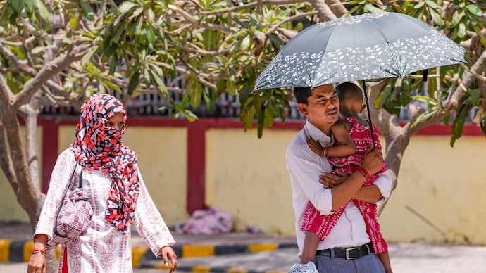 People shield themselves from the scorching heat on in New Delhi on May 18. (Photo: PTI) A hotter day closer to monsoon: What Tuesday's weather has in store