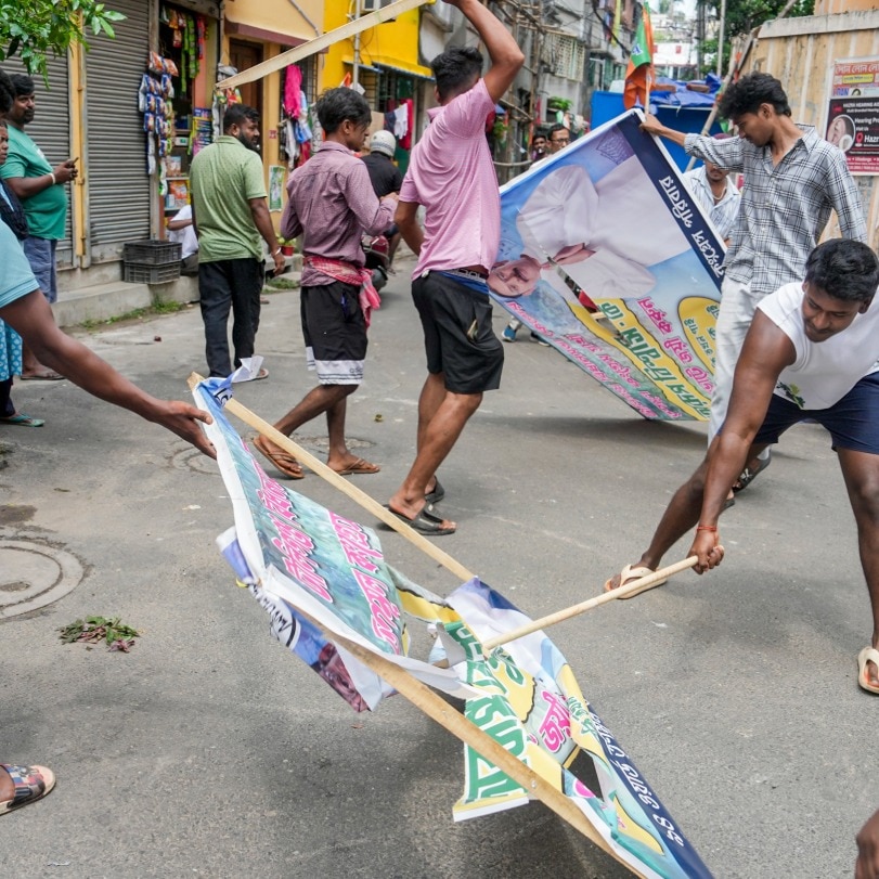 BJP supporters remove TMC hoardings from the streets of Tollyganj constituency after BJP wins the West Bengal Assembly elections, in Kolkata. (PTI)