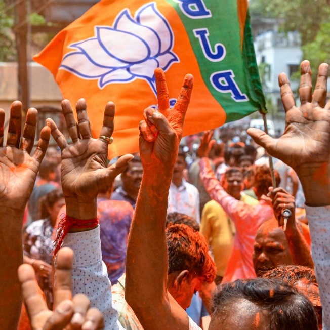 BJP workers celebrate as the party's win on the West Bengal Assembly elections in Dakshin Dinajpur's Balurghat. (PTI Image)