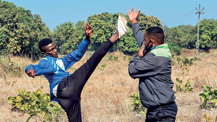 COVETED TALENT (Left) Izamam Majgul, an athlete from the Siddi community, with his coach in Junagadh, Jan. 6, 2021 (Photo: AFP)