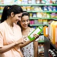 Happy mother and daughter reading product information while shopping at supermarket Happy mother and daughter reading product information while shopping at supermarket