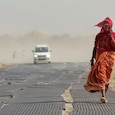 A woman covers her face while walking along a road amid dusty winds and scorching heat during a heatwave in Prayagraj (PTI Photo) A woman covers her face while walking along a road amid dusty winds and scorching heat during a heatwave in Prayagraj (PTI Photo)