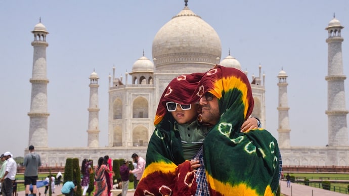 A man covers himself and a child due to intense heatwave on a hot summer day, at Taj Mahal, in Agra. (Photo: PTI) Heatwave alert
