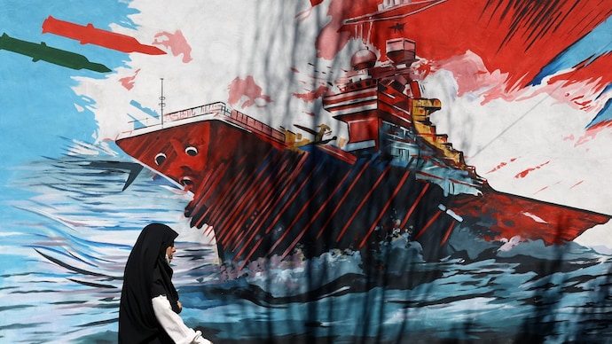 A woman walks next to a mural on a street in Tehran, Iran, May 18, 2026. (Reuters photo) Iran war