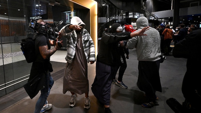 A group of supporters surround an Islamic State-linked family, as they arrive at Melbourne international airport in Australia on May 7, 2026. (Reuters photo) IS families