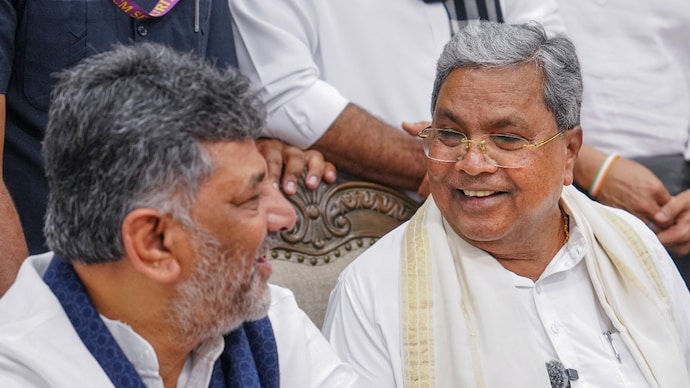 Karnataka Deputy Chief Minister DK Shivakumar in a conversation with Congress leader Siddaramaiah during a press conference after the latter resigned from the post of state Chief Minister. (Image: PTI) Karnataka Deputy Chief Minister DK Shivakumar in a conversation with Congress leader Siddaramaiah during a press conference after the latter resigned from the post of state Chief Minister. (Image: PTI)