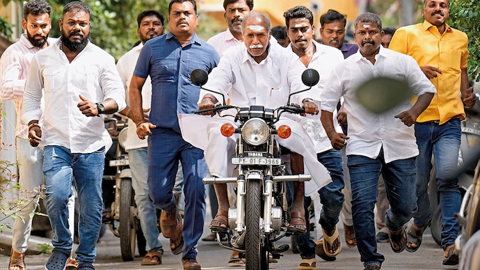 EASY RIDER: Puducherry CM N. Rangasamy arrives on a motorcycle to cast his vote, Apr. 9. (Photo: PTI)