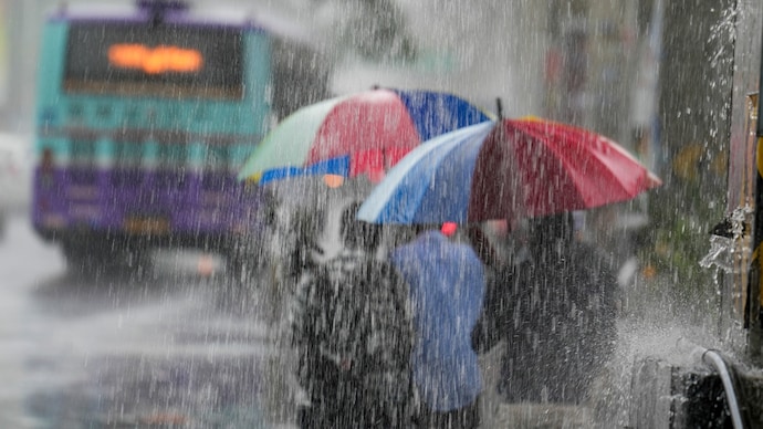 People walk with umbrealla's during rainfall. (Photo: PTI) People walk with umbrealla's during rainfall