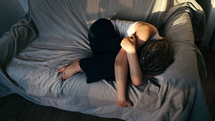 Nearly 1.2 billion people globally were living with a mental disorder in 2023, almost double the number recorded in 1990. (Photo: Getty Images) Portrait of a dreadlocks braid topknot bun woman lying and sleeping on the sofa. Concept of depression, loneliness, problems of adolescence
