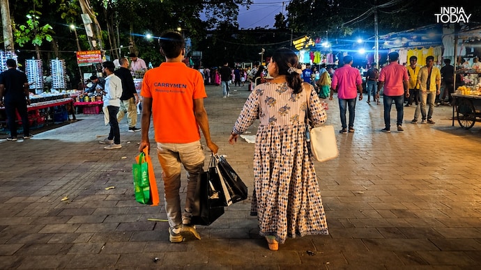 In Delhi's Lajpat Nagar Market, you can now hire someone to carry your shopping bags. shopping assistant carrying bags