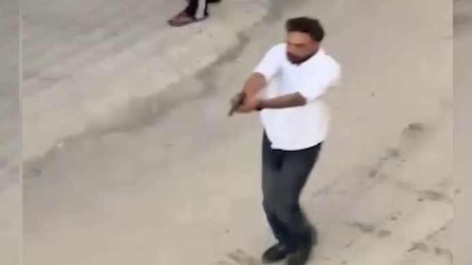 The footage purportedly shows a tourist wearing a white shirt openly walking through the market while brandishing a pistol. The footage purportedly shows a tourist wearing a white shirt openly walking through the market while brandishing a pistol.