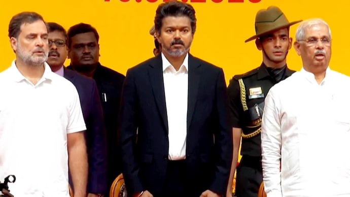 According to the new guidelines, the 3-minute-10-second version of Vande Mataram was played before the national anthem. The moment captures the national song being played at the swearing-in ceremony, with Vijay and “brother” Rahul Gandhi seen standing next to each other. (Photo: PTI) Vijay swearing-in ceremony